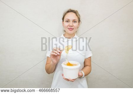 Portrait Of A Woman With A Jar Of Sugar Paste For Sugaring.beautician Holding A Jar Of Sugar Paste F
