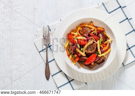 Lomo Saltado, Peruvian Dish Of Stir-fried Slices Of Beef Sirloin, Onions, Yellow Peruvian Chilis, An