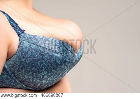 Big Natural Breasts In Blue Bra Close-up, Biggest Boobs On Gray Background