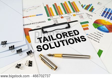 Business Concept. On The Table Among Financial Graphs And Charts Lies A Tablet With The Inscription 