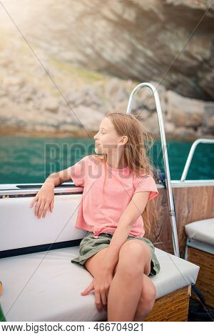 Adorable Girl Sailing On Boat In Clear Open Sea On Summer Vacation