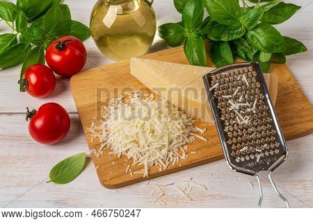 Parmesan And Hand Grater On A Cutting Board. Delicious Hard Cheese Grana Padano, Stainless Steel Gra