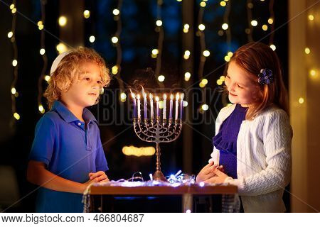 Kids Celebrating Hanukkah. Jewish Festival Of Lights. Children Lighting Candles On Traditional Menor