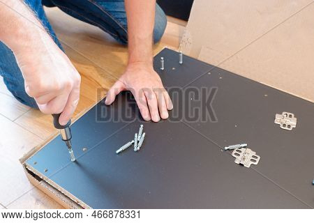 Assembling Furniture. Furniture Assembly Worker Assembles Shelf. Worker Assembling Furniture. Contra