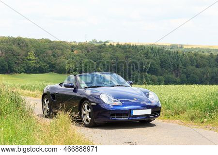 Hunsrueck, Germany - June 26, 2021: Blue Roadster Porsche Boxster 986 With Hunsrueck Mountain Panora