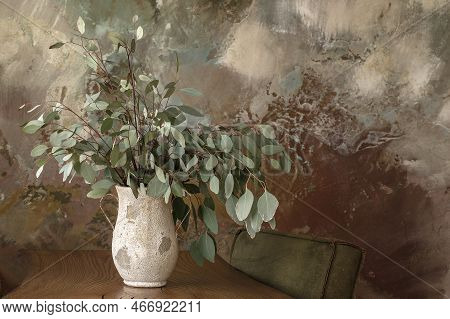 Modern Japandi Appartment Interior Design In Earth Tones, Textured Vase With Fresh Eucalyptus Agains
