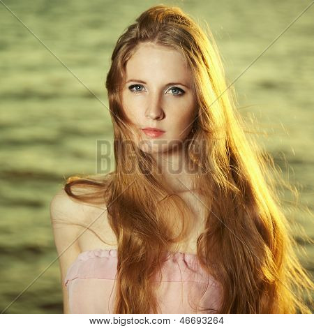 Schöne rothaarige Mädchen am Teich