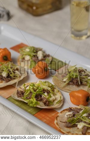 Close Up Of Chalupas, Typical Mexican Dish Made With Tortillas, Sauce, Cheese, Meat And Lettuce On P