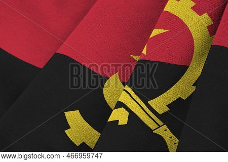 Angola Flag With Big Folds Waving Close Up Under The Studio Light Indoors. The Official Symbols And 