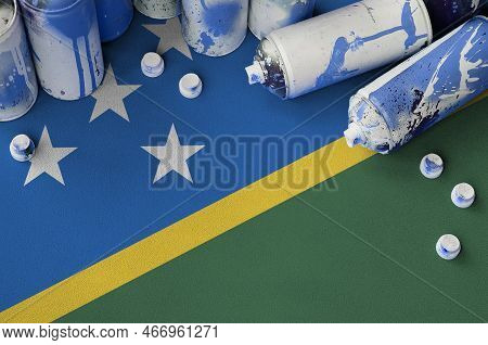 Solomon Islands Flag And Few Used Aerosol Spray Cans For Graffiti Painting. Street Art Culture Conce