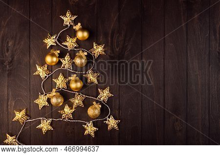 Cozy Dark Christmas Background With Golden Christmas Tree Shape Of Decoration - Balls, Stars On Glow