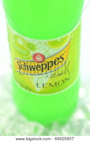 Bottle of Schweppes drink on ice cubes