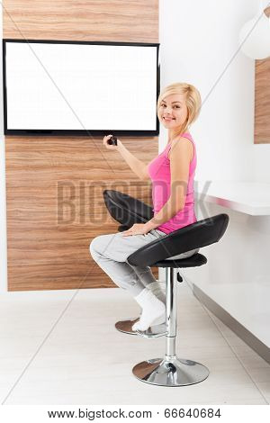 woman smile watching tv rmote control channel