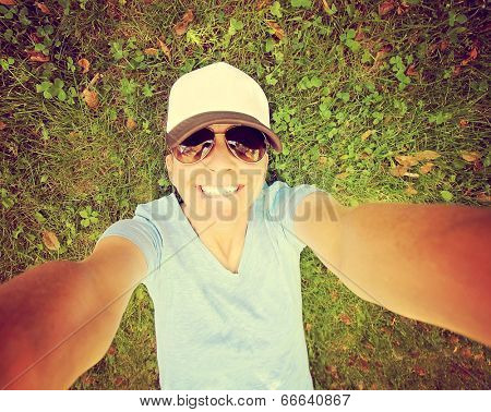  a cute girl in the grass, smiling at the camera on a bright sunny day done with a retro vintage instagram filter 