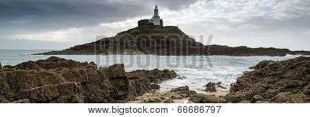 Landscape Panorama Of Mumbles Lighthouse In Wales With Sunbeams Over Sea