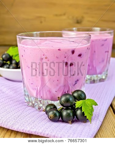 Milkshake with blackcurrants on napkin and board