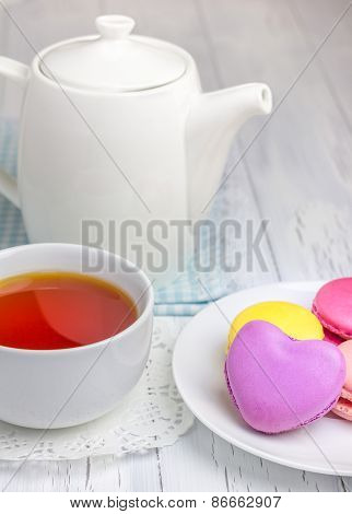 A Cup Of Tea With Colorful Macarons