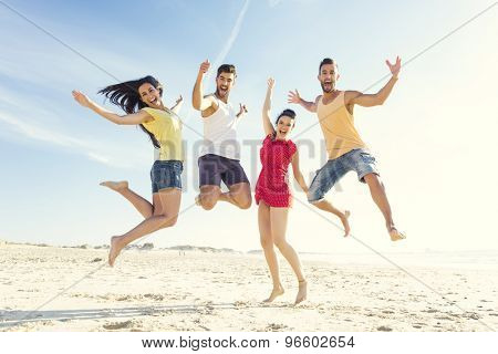 Group of friends making a jump together at the beach