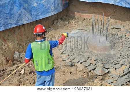 Construction workers spraying the anti termite chemical treatment to the pile cap