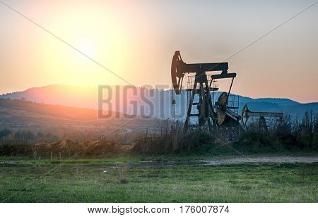 oil pump on orange sunset. Close up