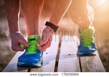 Athlete during training tying shoelaces on sneakers summer.