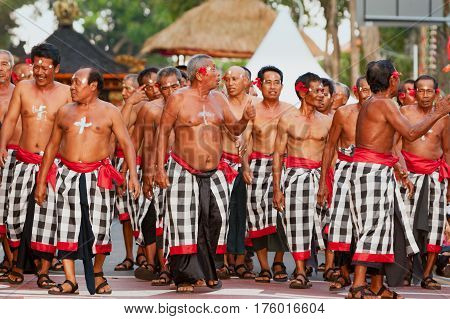 DENPASAR BALI ISLAND INDONESIA - JUNE 11 2016: Group of Balinese senior people. Beautiful dancer men in traditional kecak dance costumes on street parade at art and culture festival.