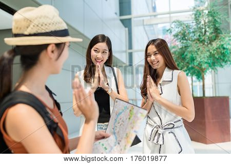 Woman traveler holding city map and say good bye to the local people in Bangko city