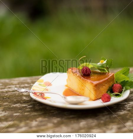 Delicious homemade Flan dessert or creme caramel dessert with mint. Slice of Milk Pudding over a wooden table. Brazilian Flan with strawberries. Panna cotta dessert with caramel sauce.