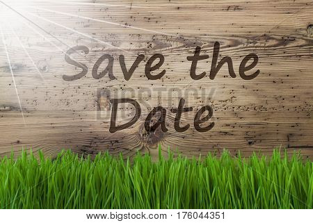 English Text Save The Date. Spring Season Greeting Card. Sunny Aged Wooden Background With Grass.