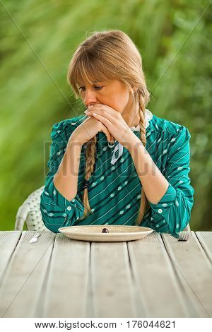 Young woman is having meager meal in times of scarcity.