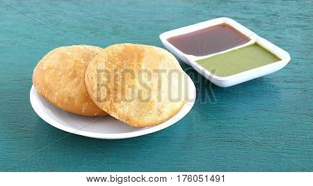 Kachori, a vegetarian food, native to the state of Rajasthan, India, and green and tamarind chutneys.