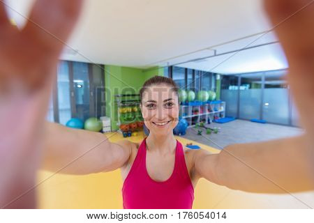 sport woman smile at camera self picture at gym, young girl picture herself exercising fitness center.