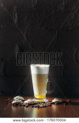 Cup of coffee latte with cakes on a black background