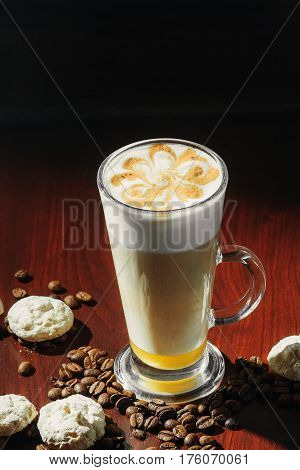 Cup of coffee latte with cakes on a black background