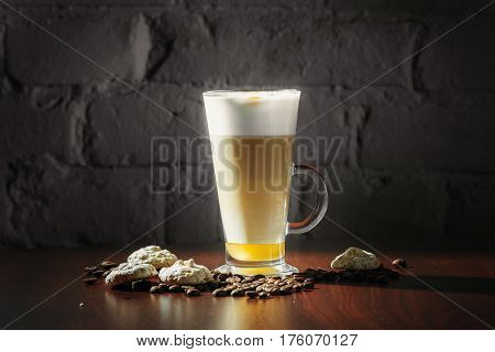 Cup of coffee latte with cakes on a black background