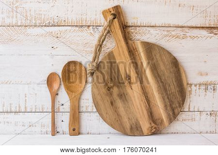 Round wooden cutting board and spoons standing on white kitchen table minimalistic style abstract kitchen interior kinfolk