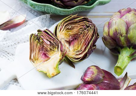 Fresh big Romanesco artichokes green-purple flower heads ready to cook seasonal food