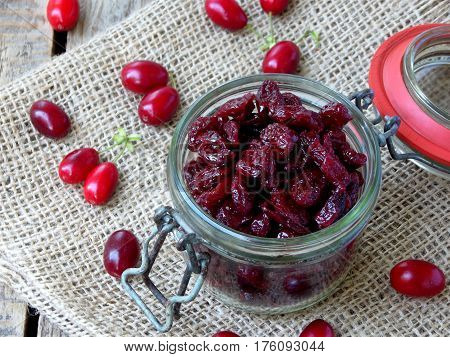 Dried Dogwood Cornelian Cherry Berry In Jar On Wooden Background. Selective Focus