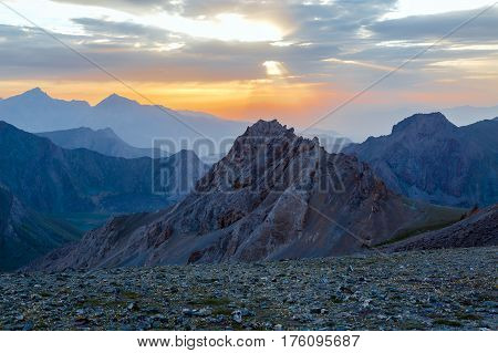 Sunset mountain panorama Silhouettes of highland ridges and peaks of warm and cool tones visible perspective distance luminous Sunset on background