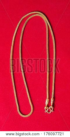 Gold Necklace 96.5 Percent Thai Gold Grade With Gold Hook Isolated On Red