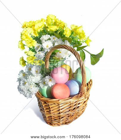Easter basket with eggs, white and yellow flowers. Isolated on white.