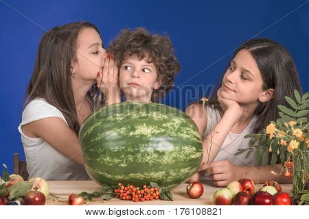 Happy kids with a whole watermelon on a blue background
