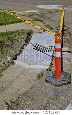 Orange cone and yellow ribbon warning motorists of newly fresh poured concrete on a curb