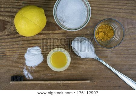 DIY toothpaste with ingredients lemon coconut oil turmeric baking soda Xylitol and bamboo toothbrush