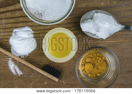 DIY toothpaste with ingredients coconut oil turmeric baking soda Xylitol and bamboo toothbrush