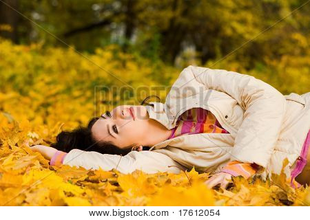 Giovane donna abbastanza sulla foglia d'autunno
