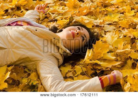 Giovane donna abbastanza sulla foglia d'autunno