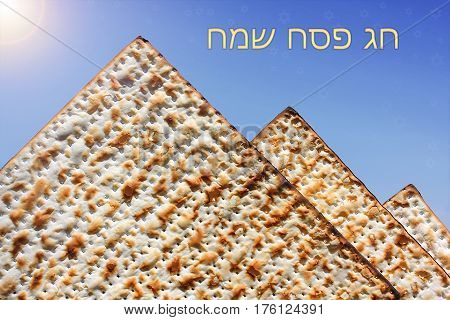 jewish holiday of Passover, stylized pyramid of matzo on the blue background with Stars of David and inscription  in hebrew - Happy Passover