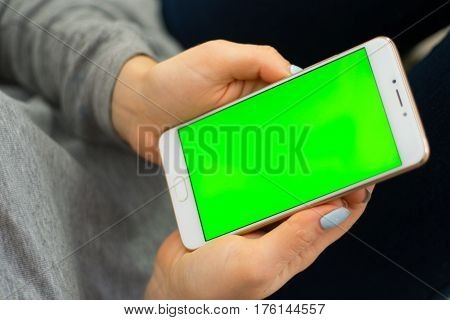 Beautiful girl holding a smartphone in the hands of a green screen green screen, hand of man holding mobile smart phone with chroma key green screen on white background, new technology concept