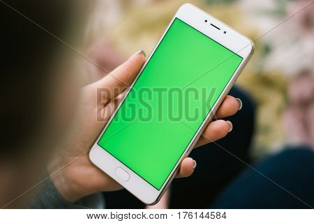 Beautiful girl holding a smartphone in the hands of a green screen green screen, hand of man holding mobile smart phone with chroma key green screen on white background, new technology concept